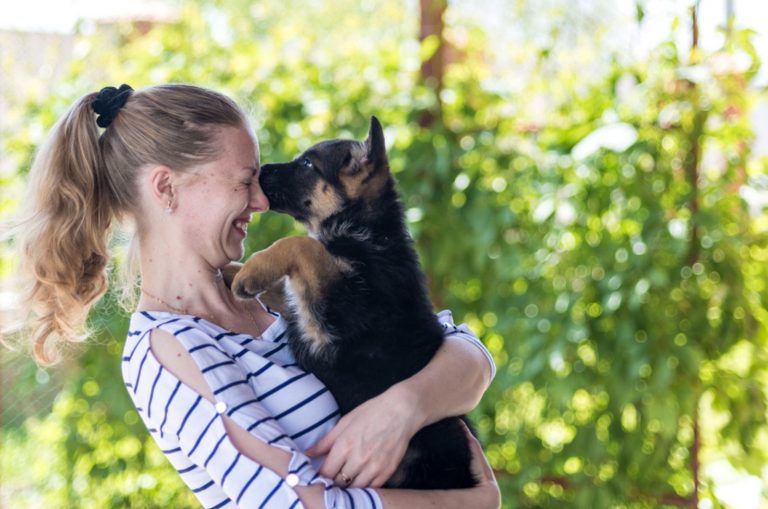 happy girl holding a small puppy german shepherd