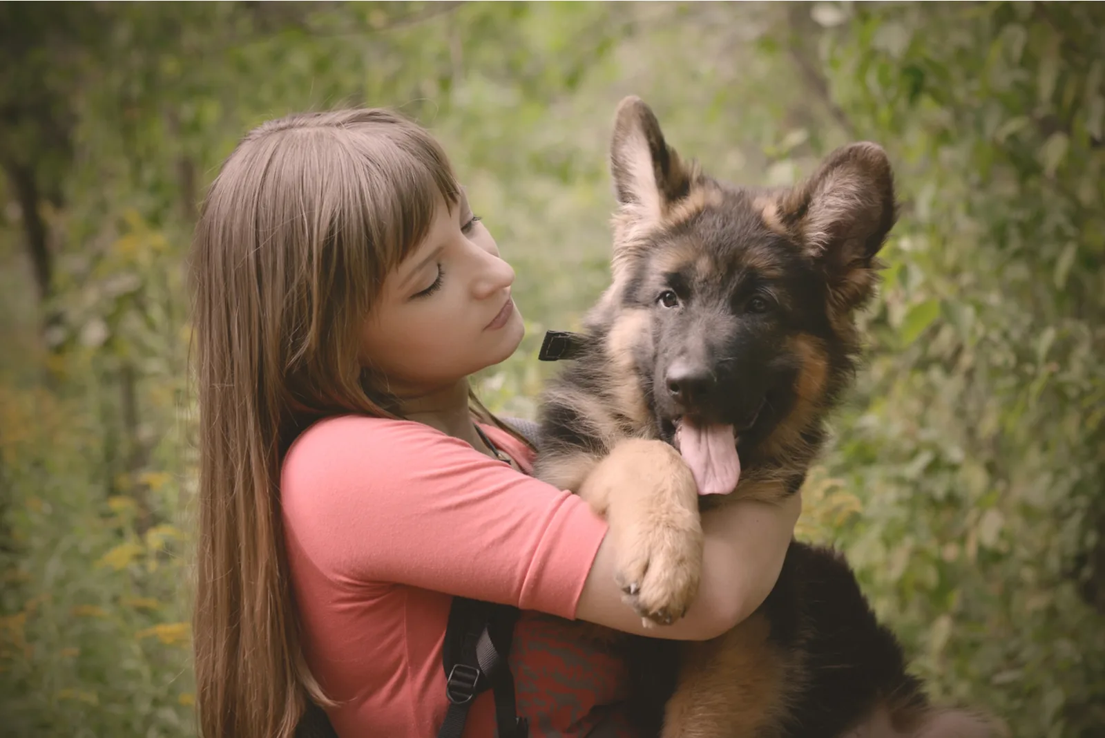 girl hugging her german shepherd pet
