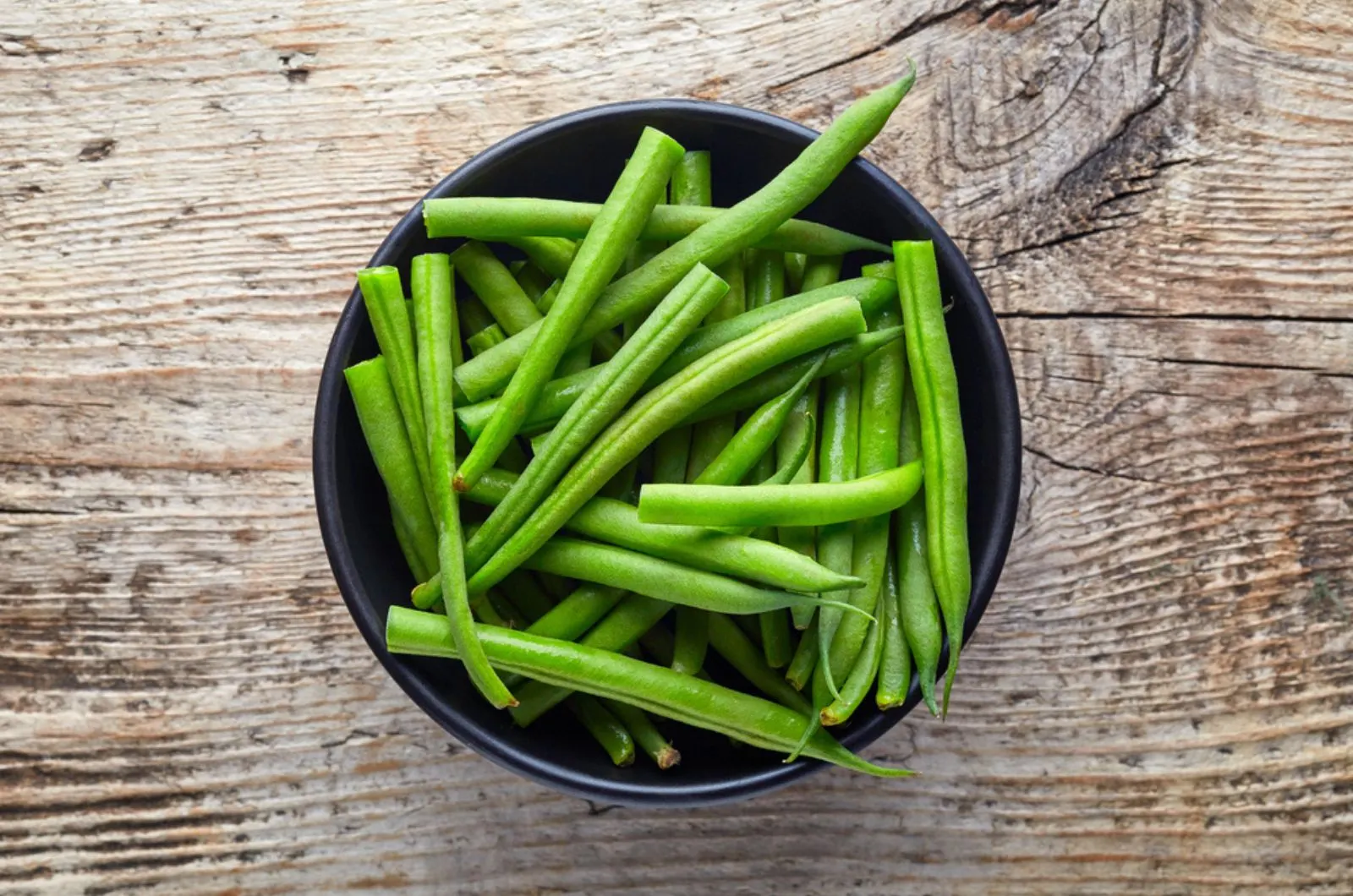 green beans in a bowl on the wooden table
