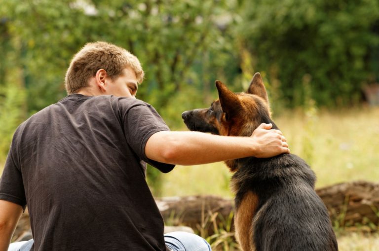 man hugging his german shepherd