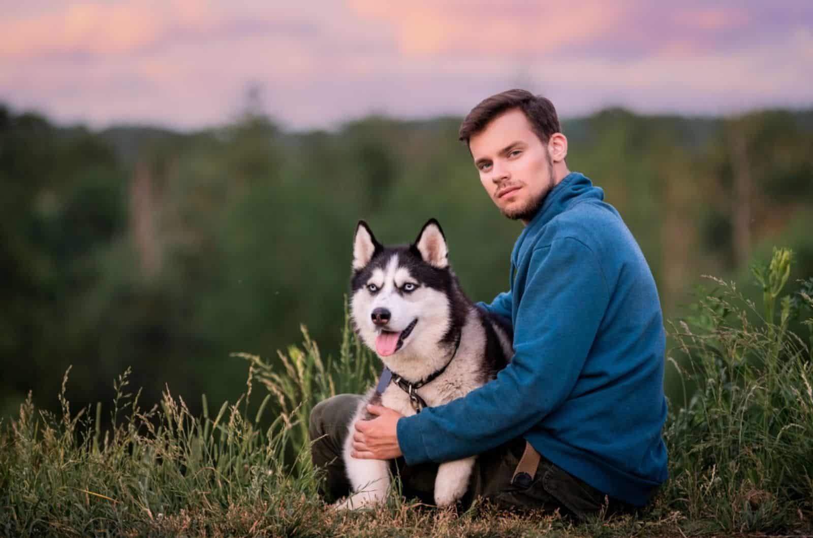 man and his pet dog siberian husky in nature