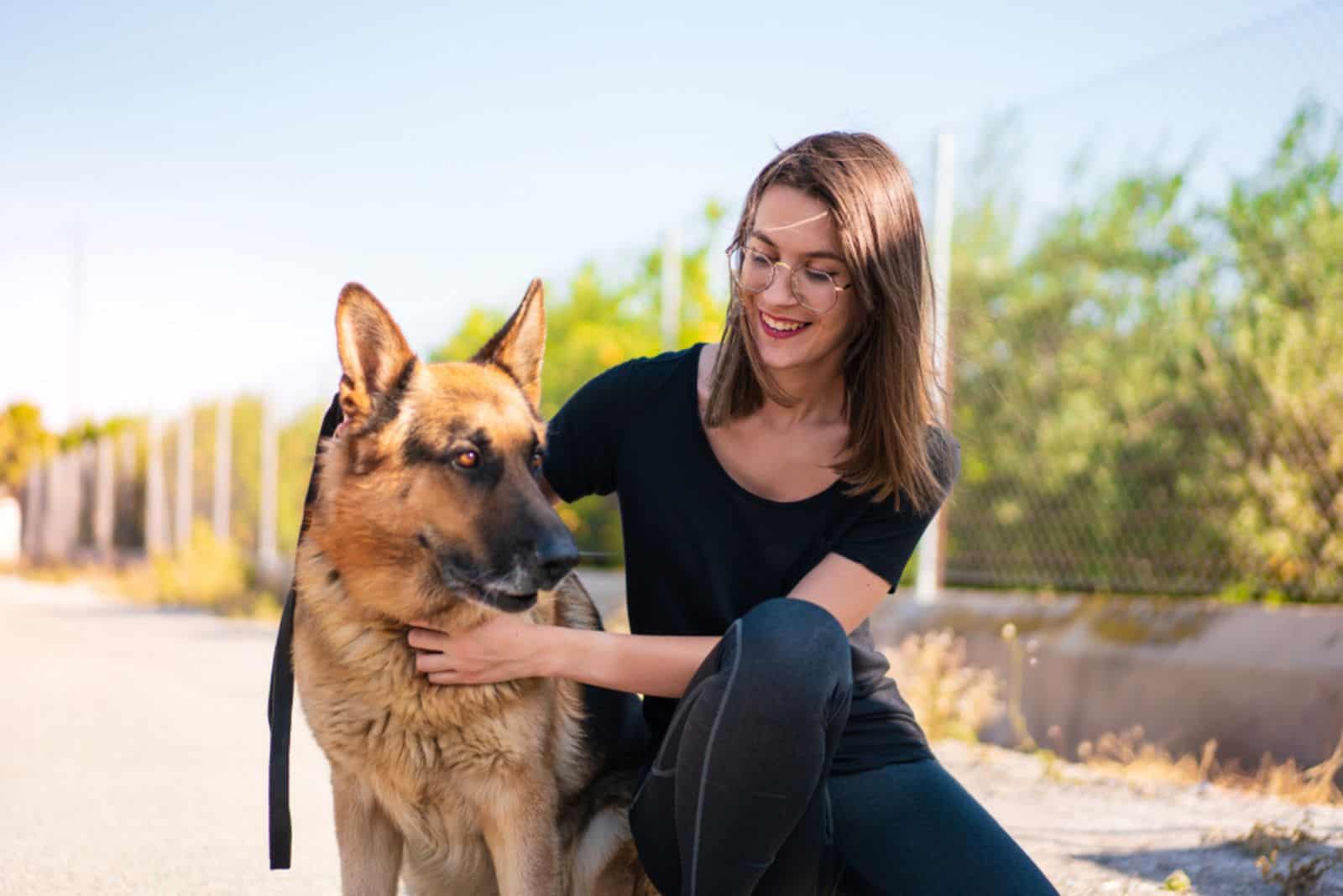 Young girl at outdoors with her german shepherd dog