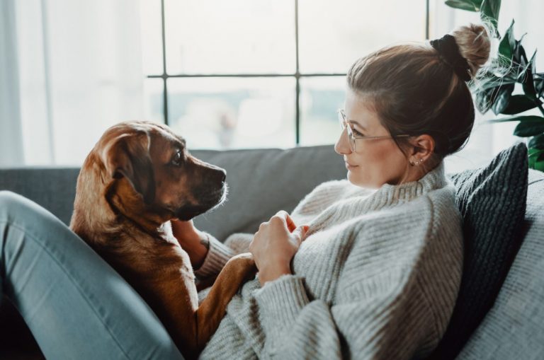 woman cuddling with her dog at home