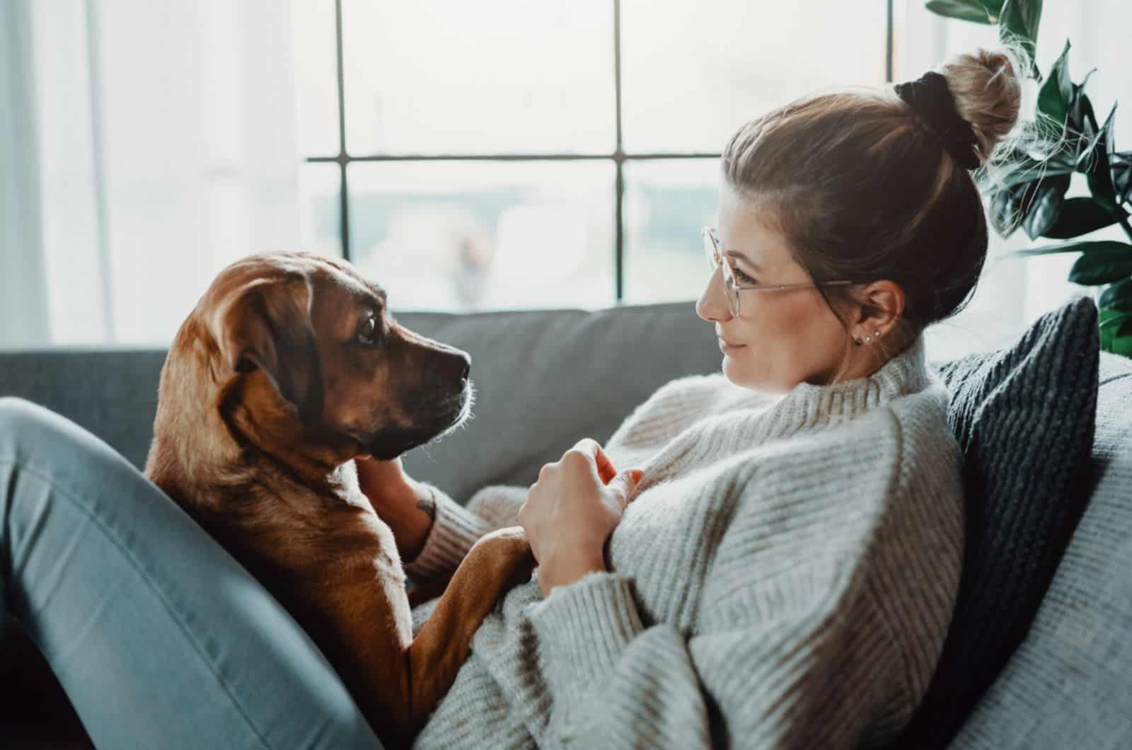 woman cuddling with her dog at home