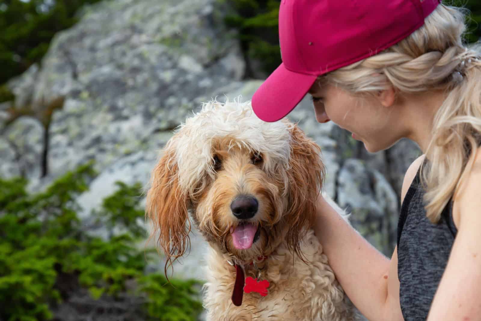 Woman Hiker is spending time with her Dog in the nature.