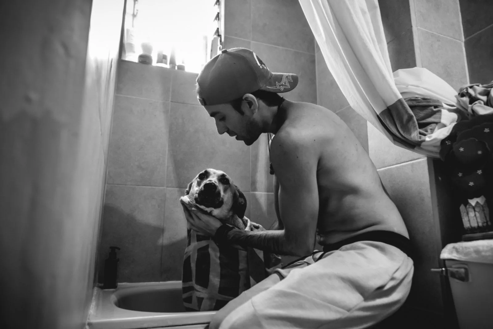 a man with a German shepherd in the bathroom