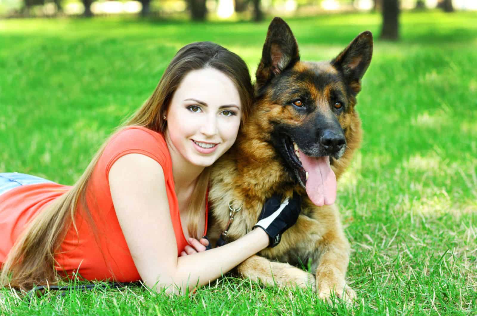 girl lying on the grass with her dog german shepherd