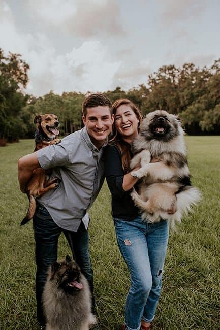 happy couple with their dogs in the park
