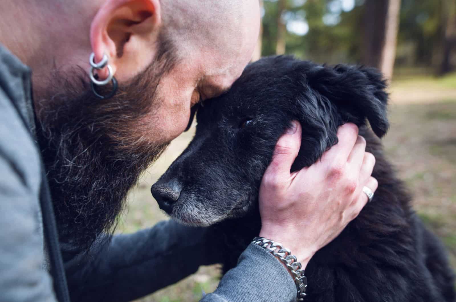 man embracing his dog in the garden