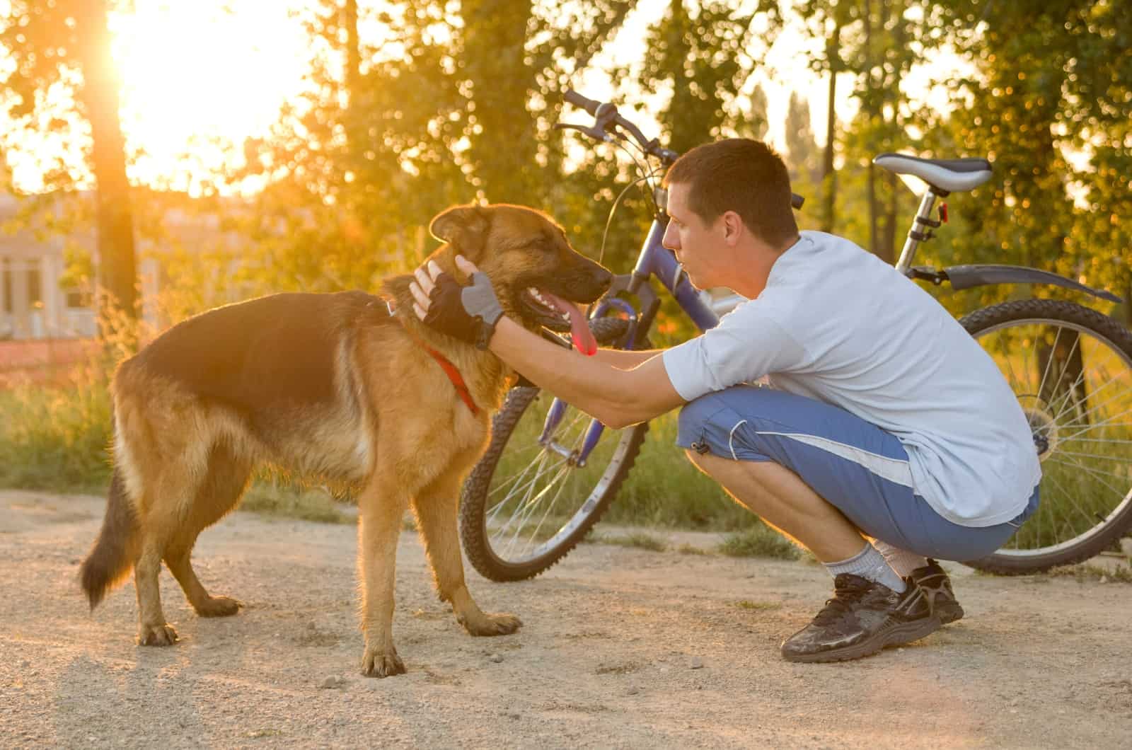 man petting his German Shepherd