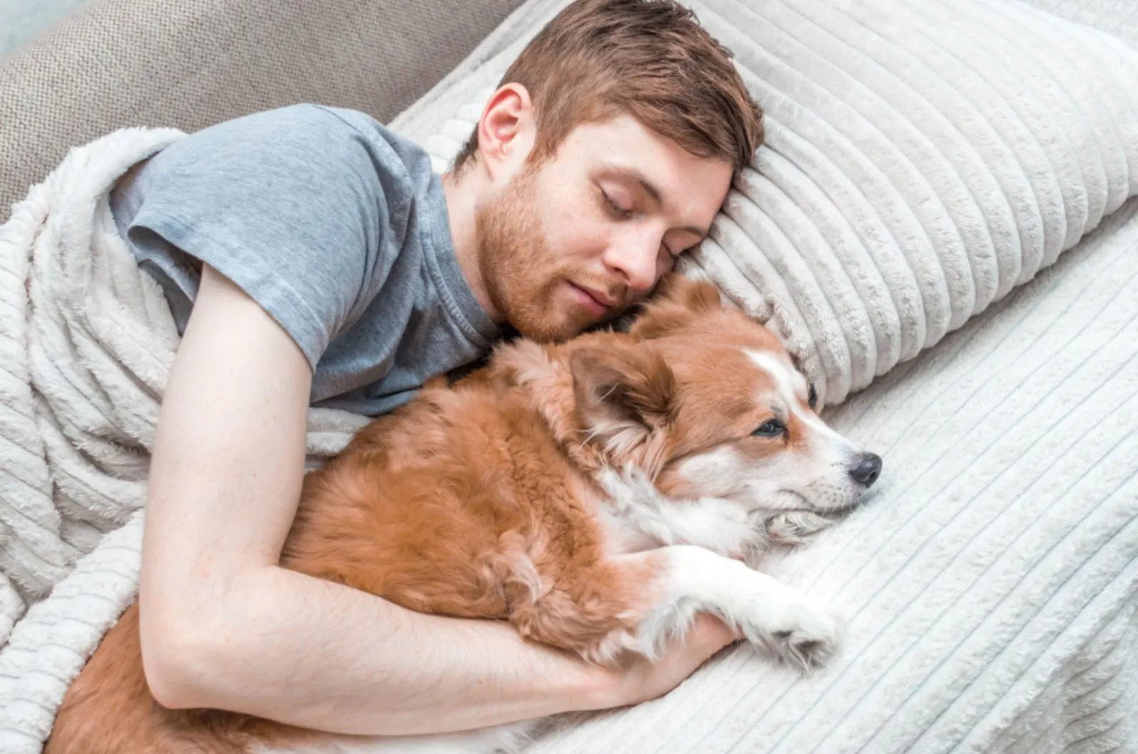 man sleeping with his dog on the couch