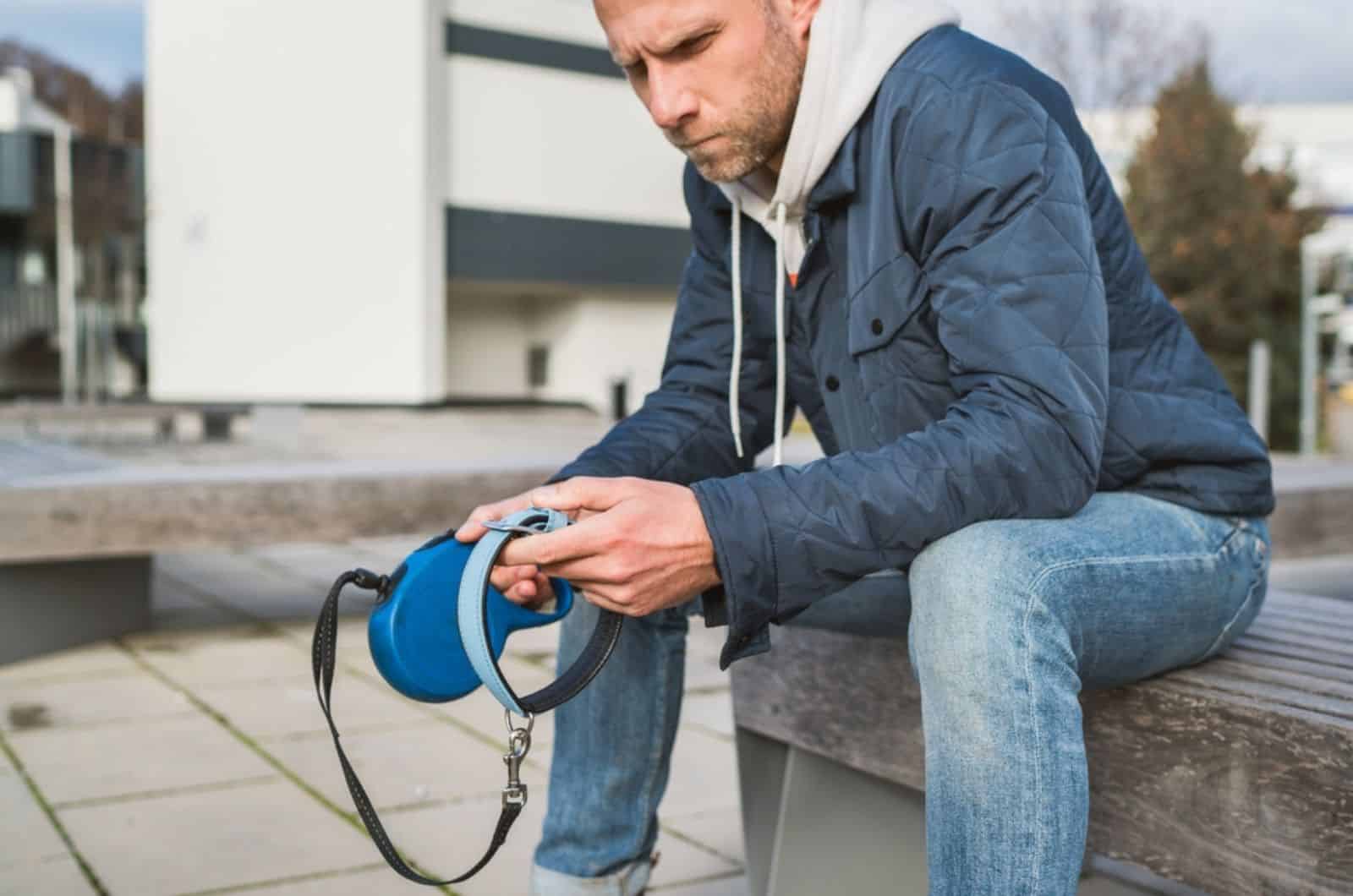 sad dog owner  is grieving sitting on a bench with the lovely pet collar