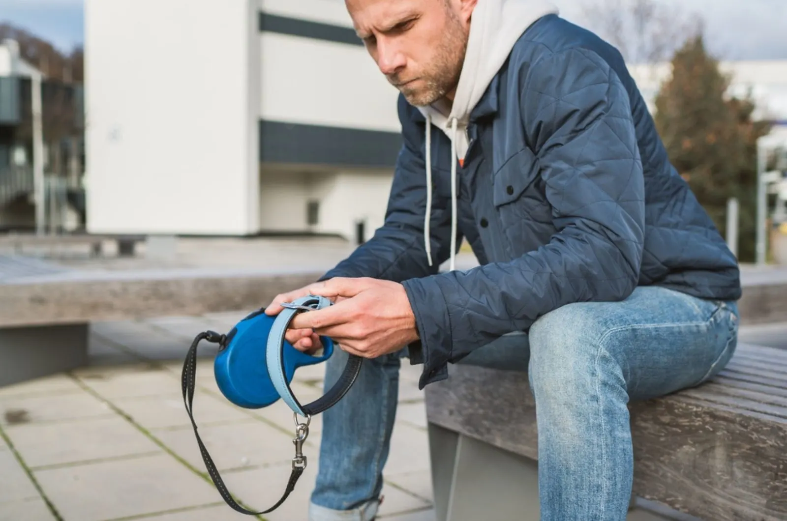 sad dog owner is grieving sitting on a bench with the lovely pet collar