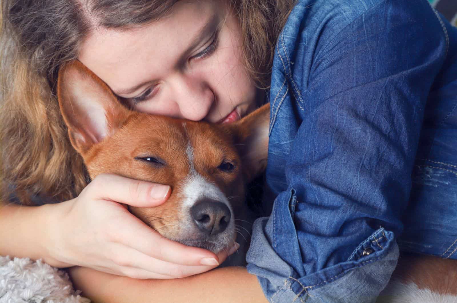 sad girl hugging her dog on the couch