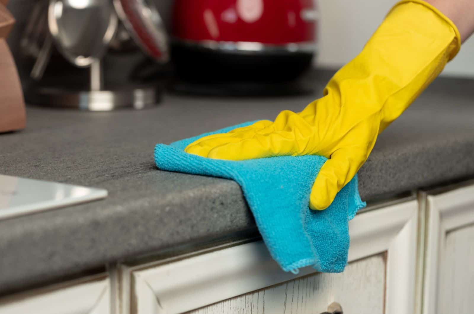 woman cleaning the counter with a blue cloth