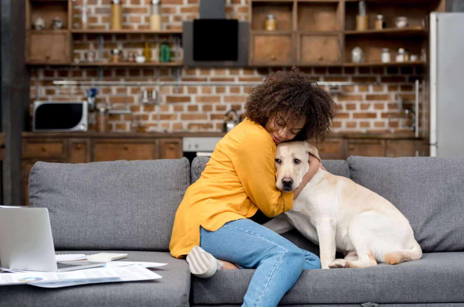woman hugging her dog on the couch