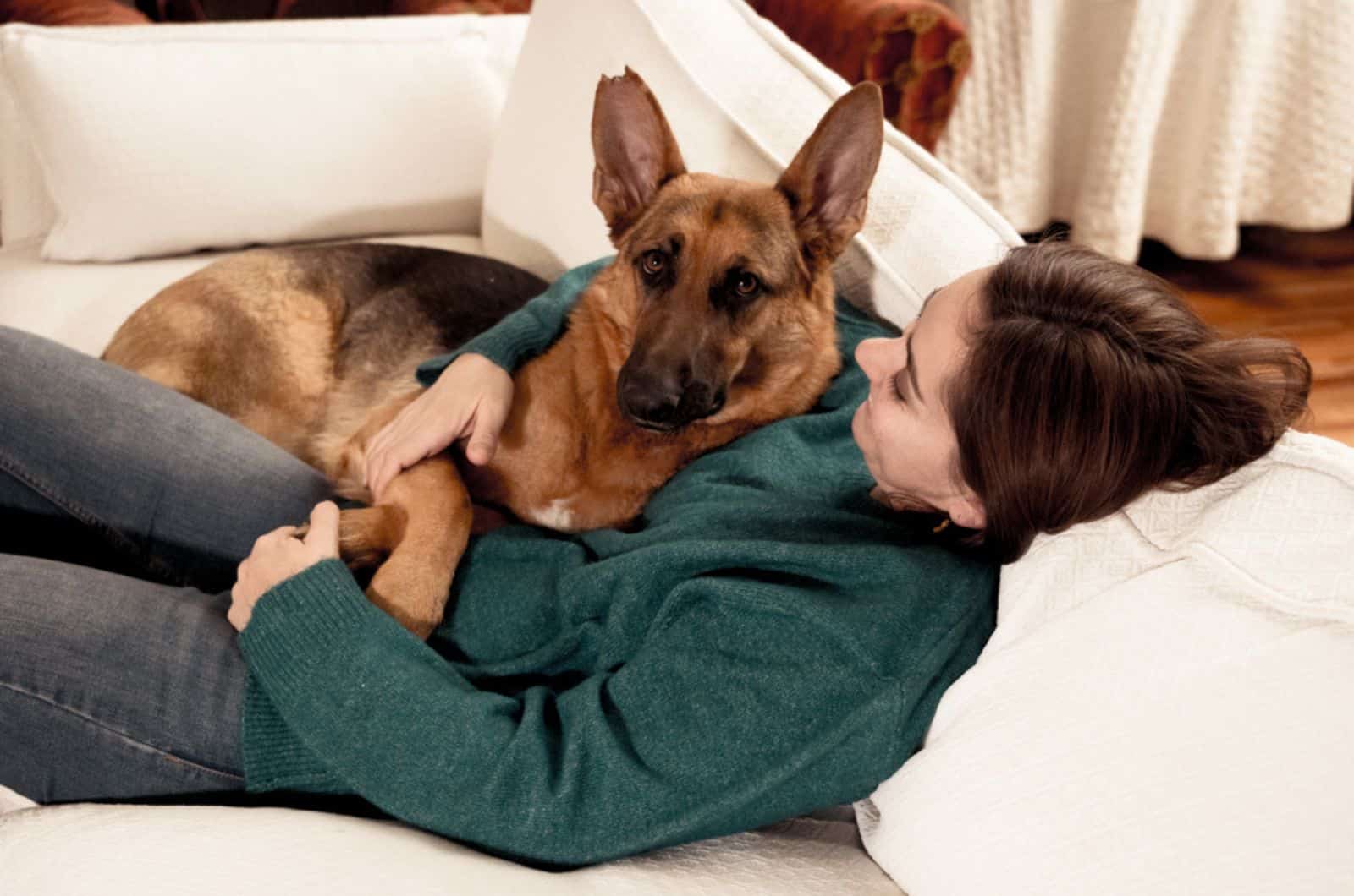 woman hugging her german shepherd on the couch