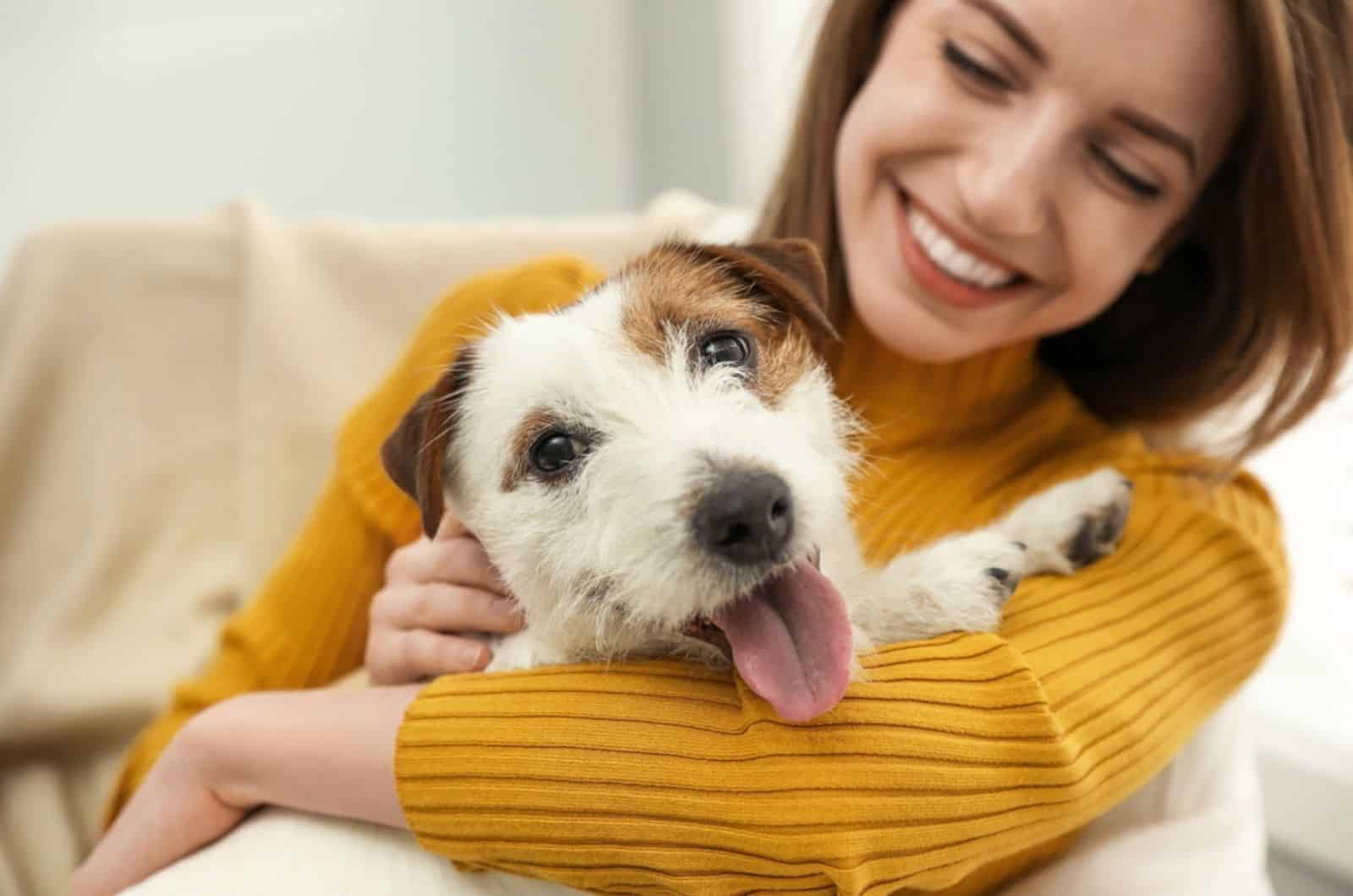 woman petting with her dog indoors
