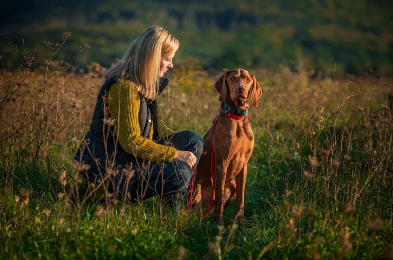 woman walking her beautiful hungarian vizsla in nature