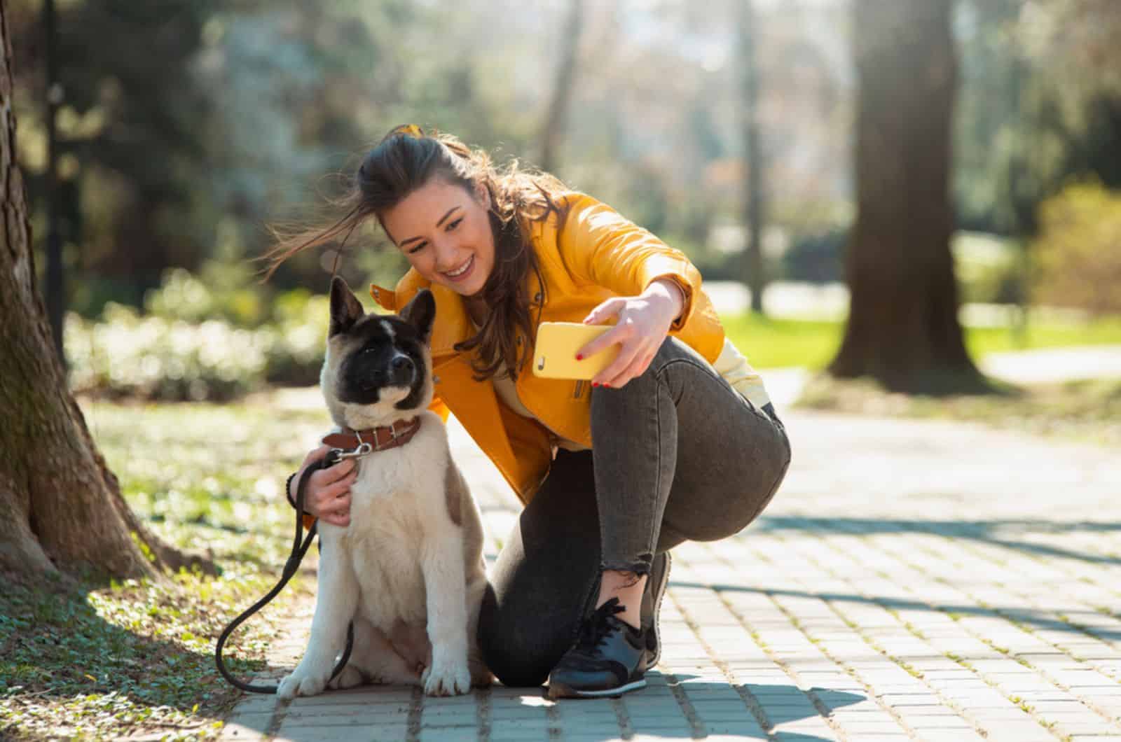woman taking photo with her dog