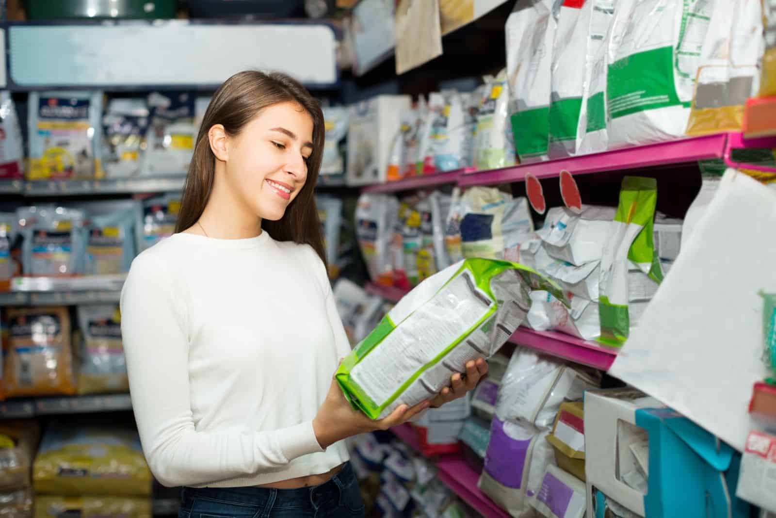 the woman looks at the dog food