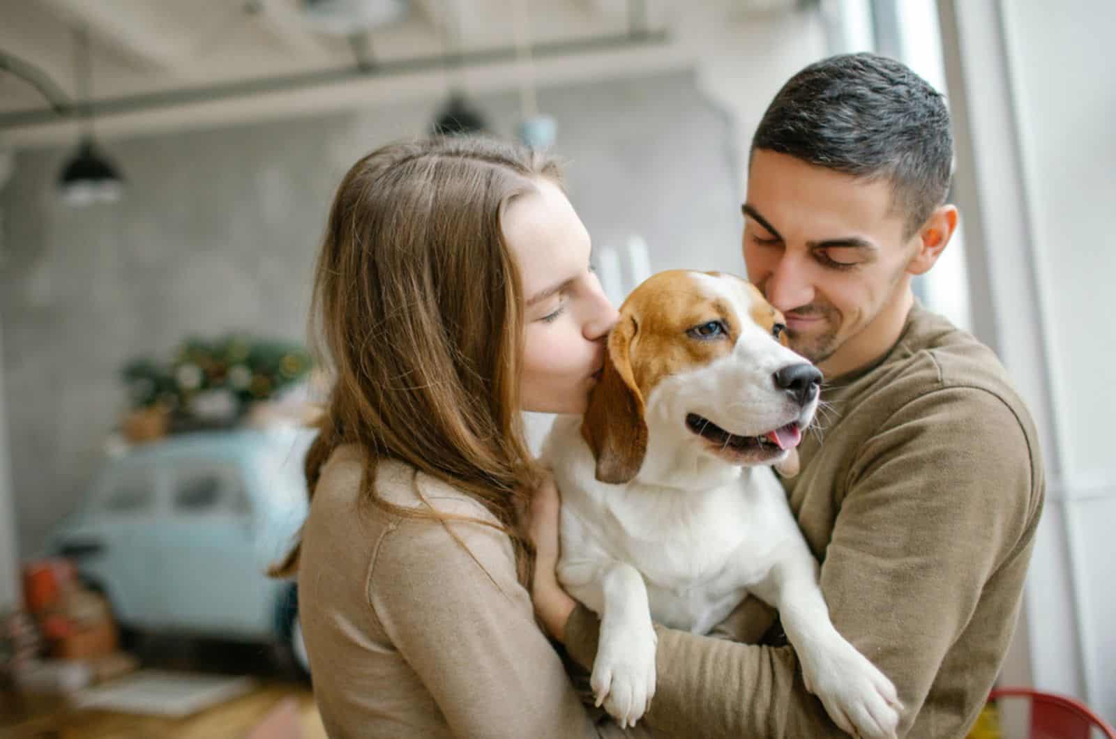 a couple hugging their dog in dining room