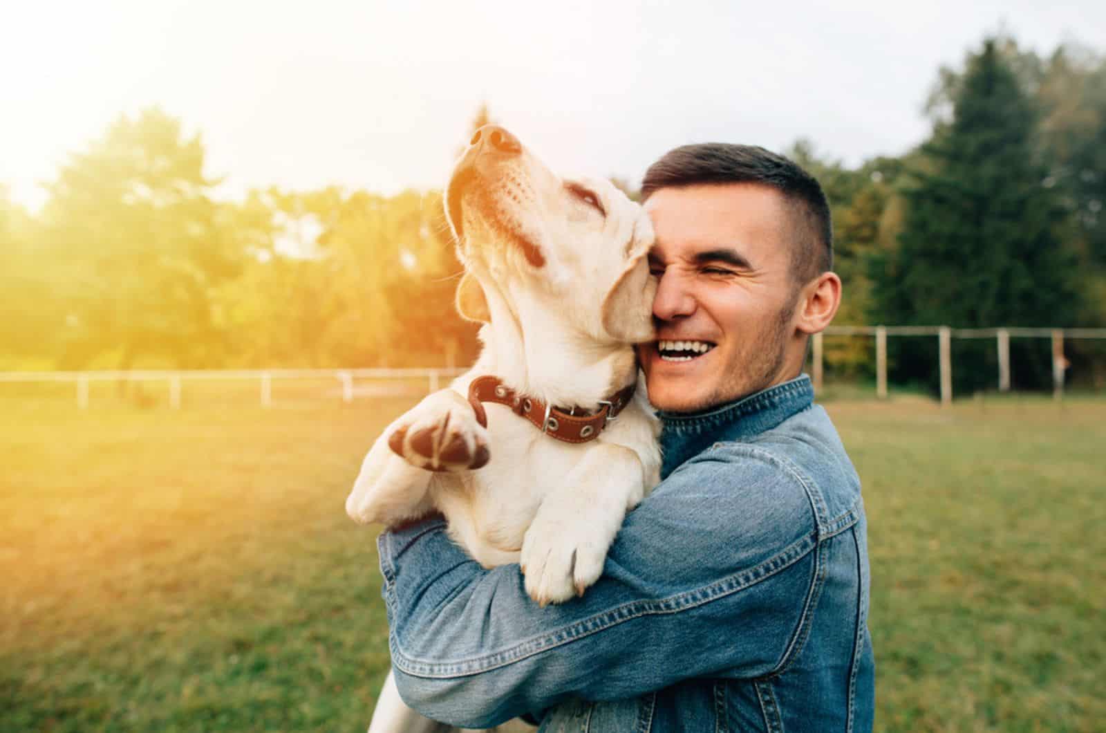 happy man hugging his dog in the park