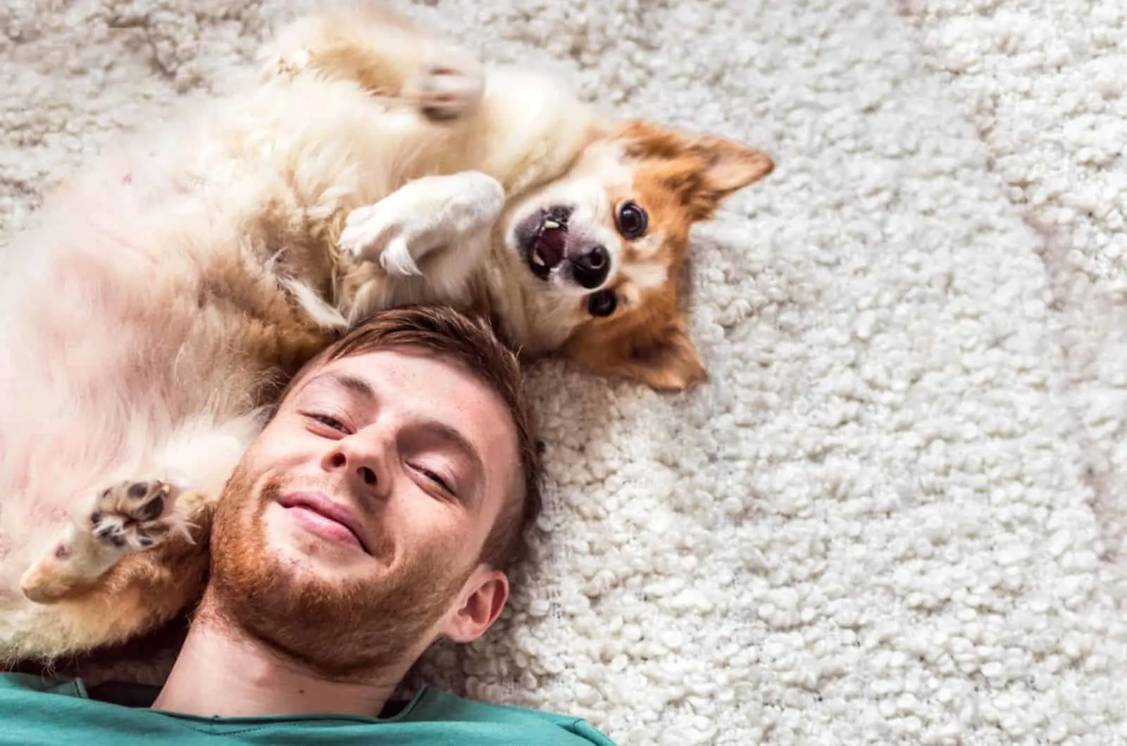 man and his dog lying on the carpet