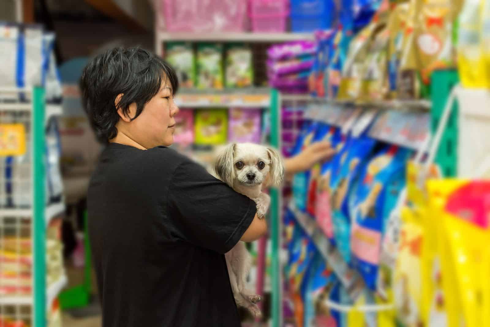 the woman looks at the dog food