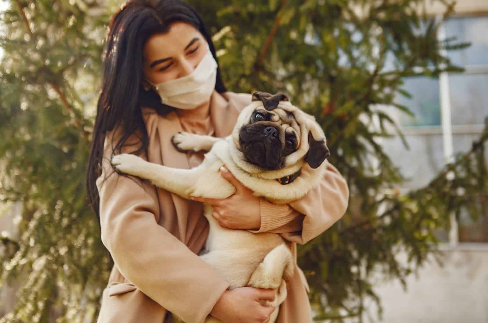 woman holding her pet pug