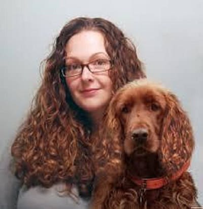 woman with curly hair holding her dog with curly hair