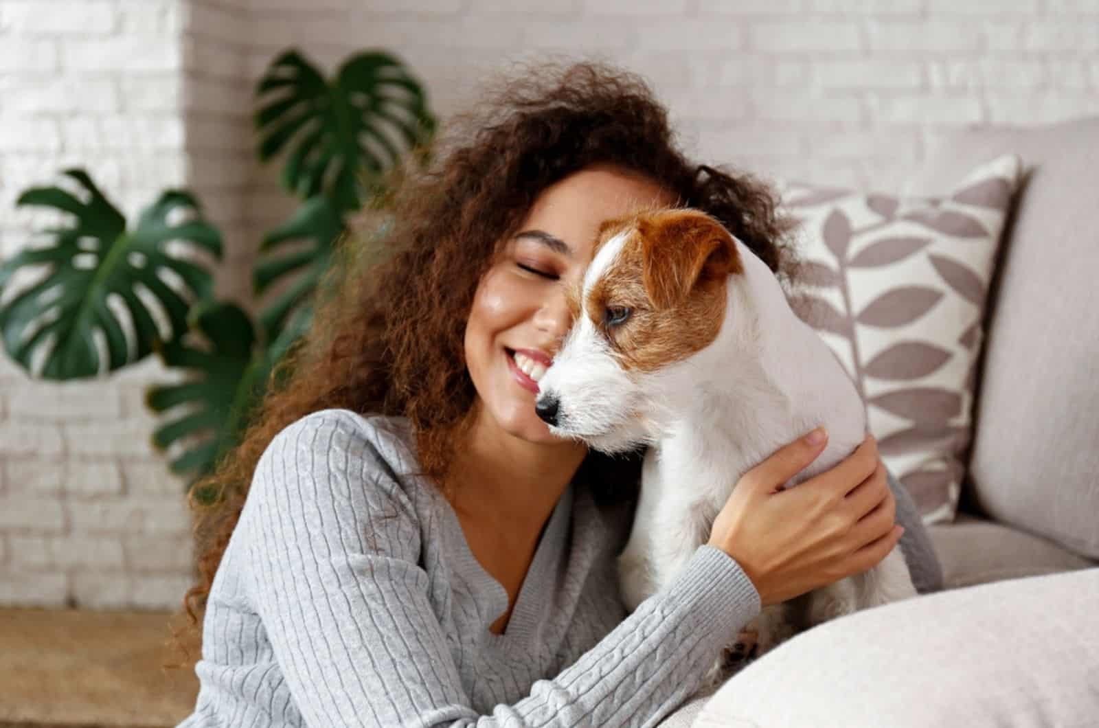 woman with her adorable wire haired jack russel terrier sitting on the couch