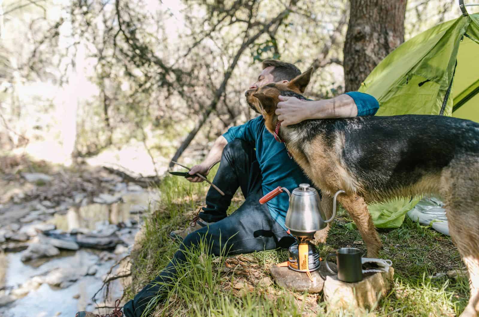 german shepherd leaning on his owner in nature