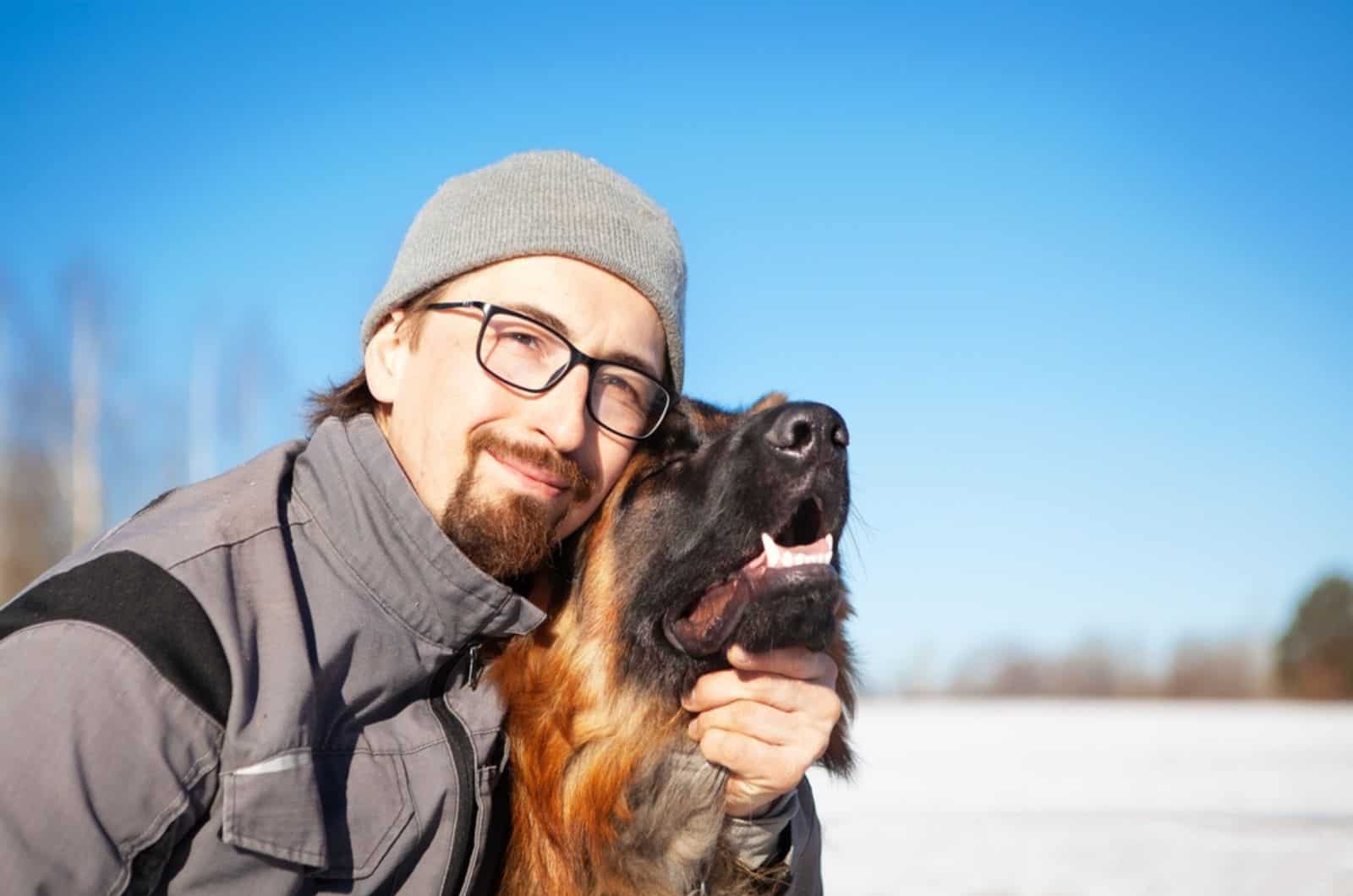 man with his german shepherd dog in winter