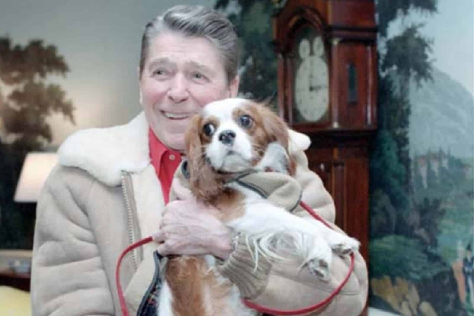 Rex Reagan holds a dog in his arms