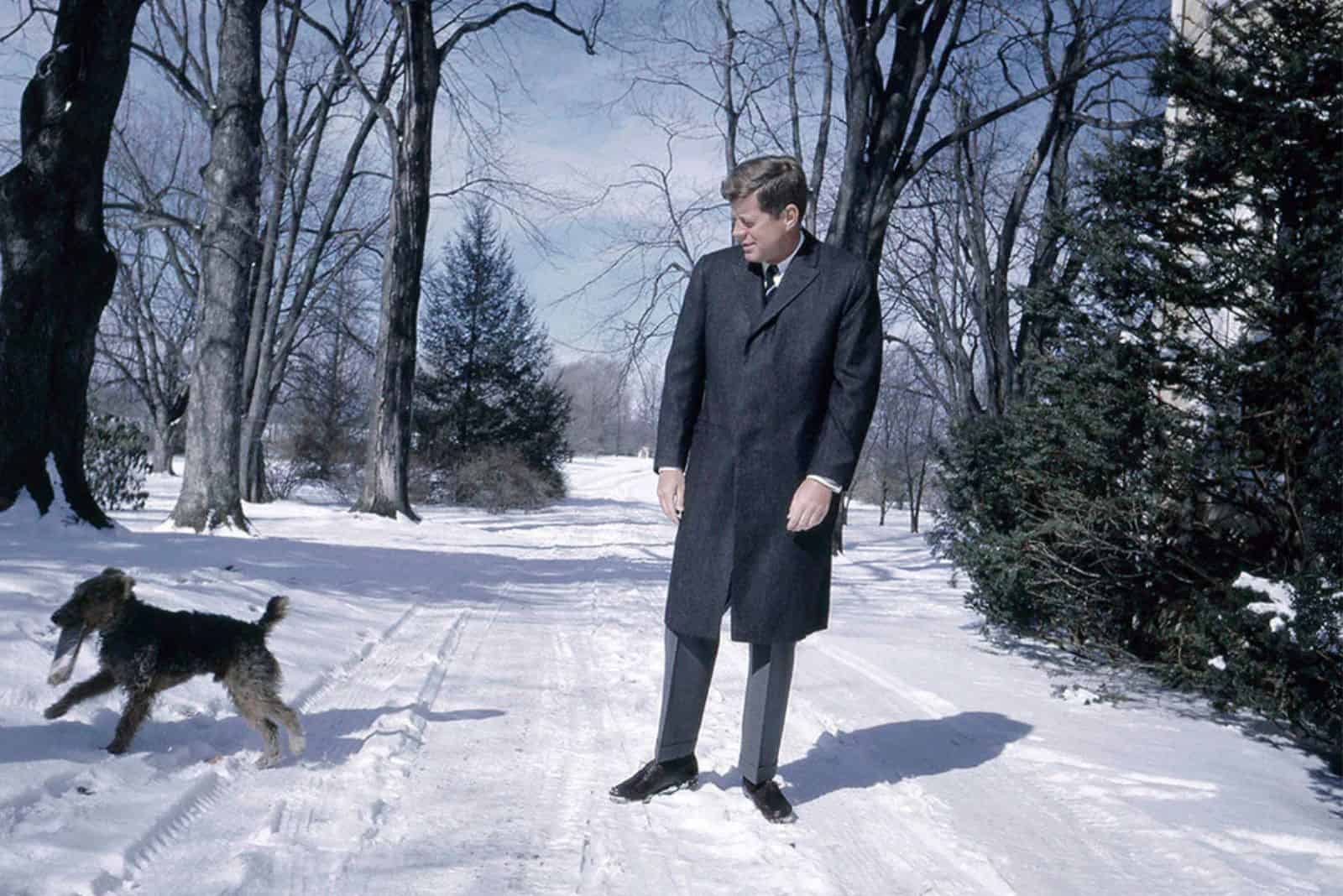a man walking with a dog in the snow