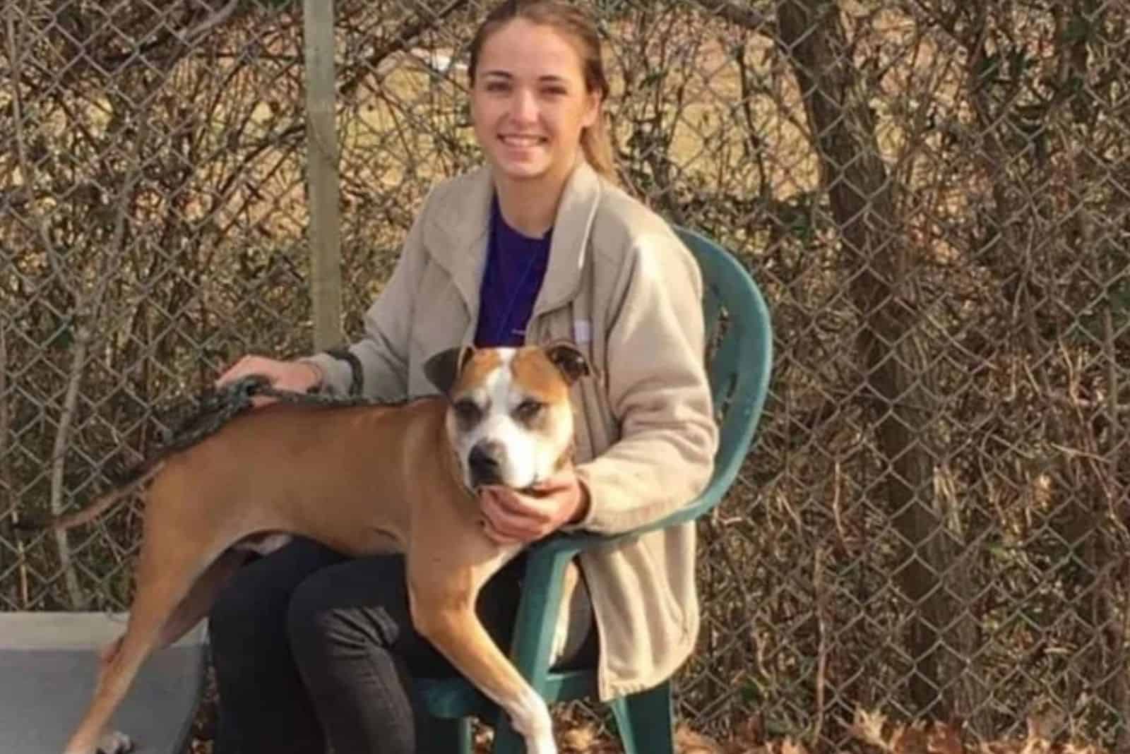 a rescued dog sits on a woman's lap