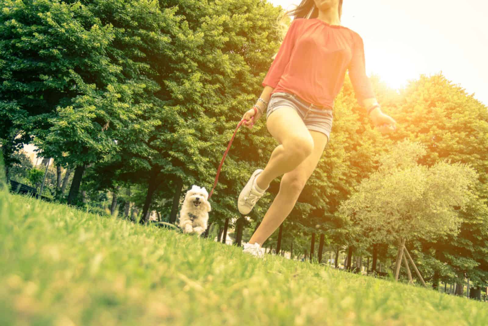 girl running with her dog in the park