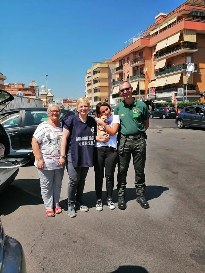 group of people with small dog posing for picture