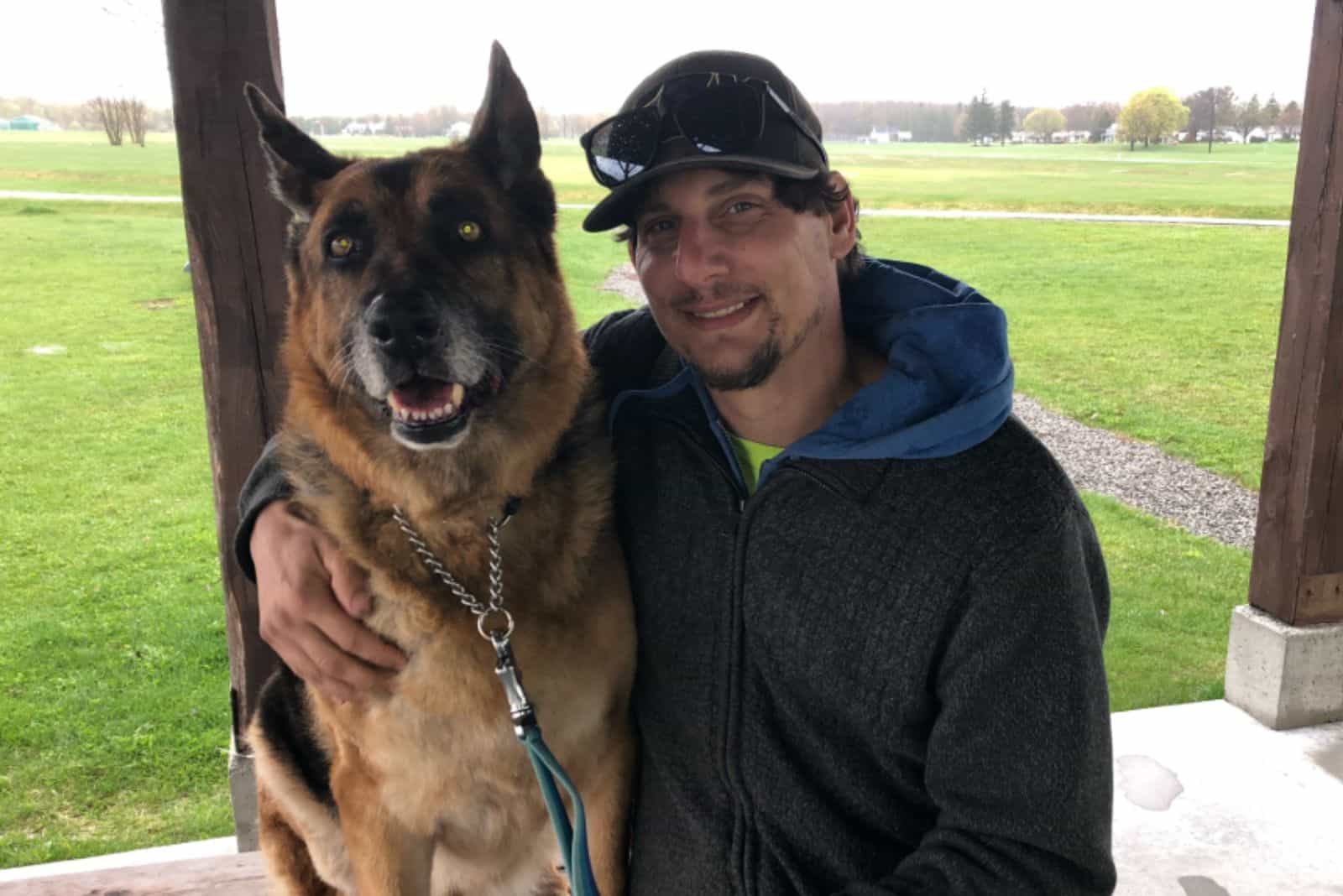 man hugging his dog german shepherd