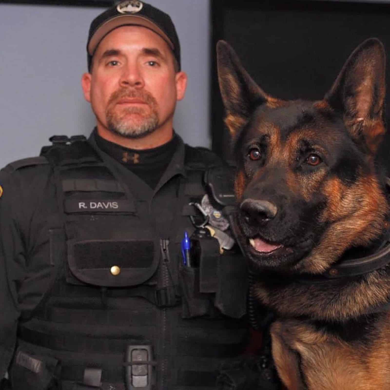 police officer and german shepherd sitting together