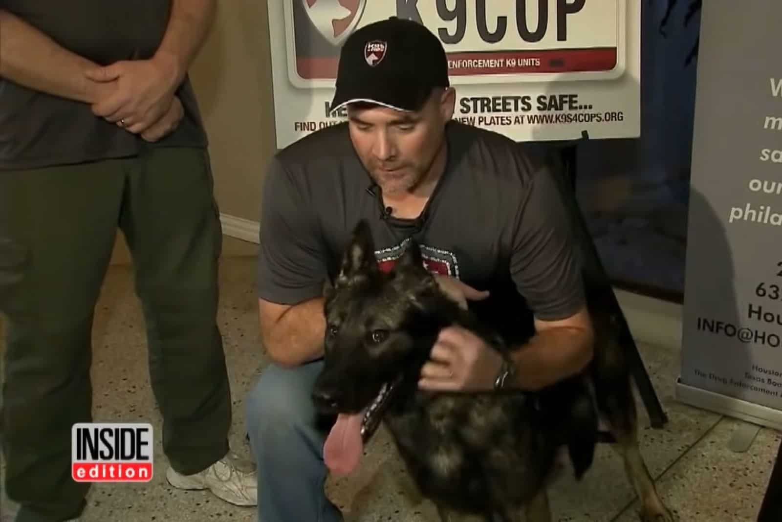 police officer cuddling german shepherd dog his new partner