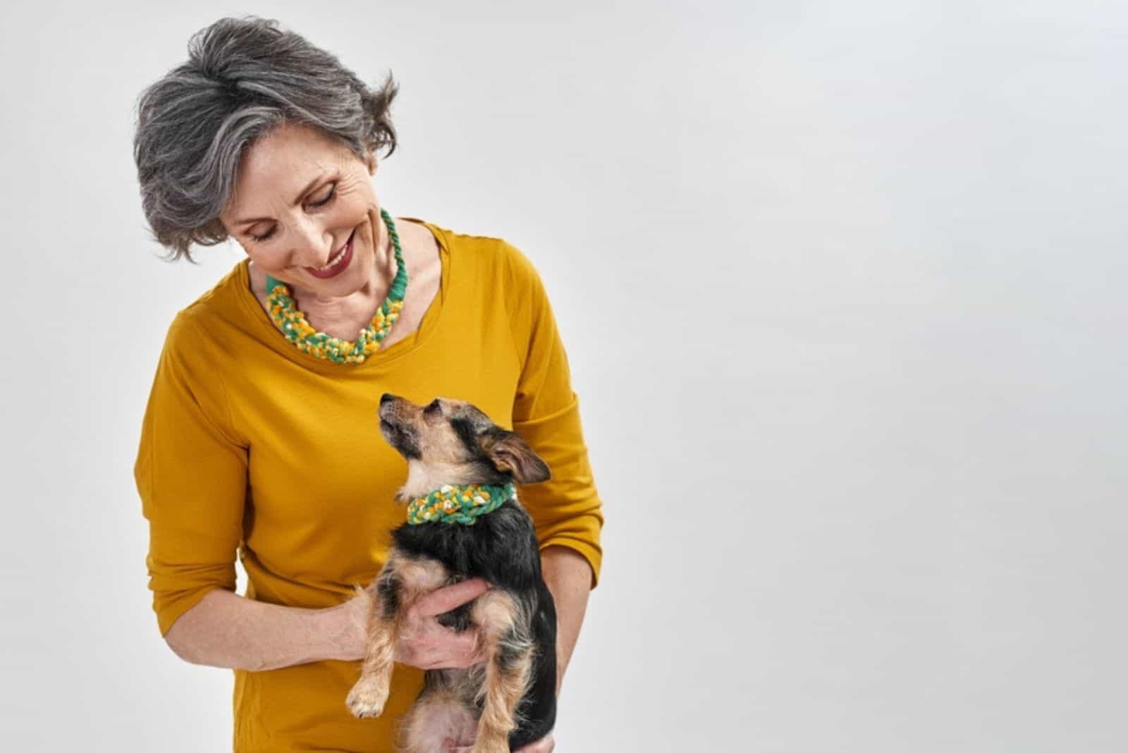 senior woman and her chihuahua dog looking at each other