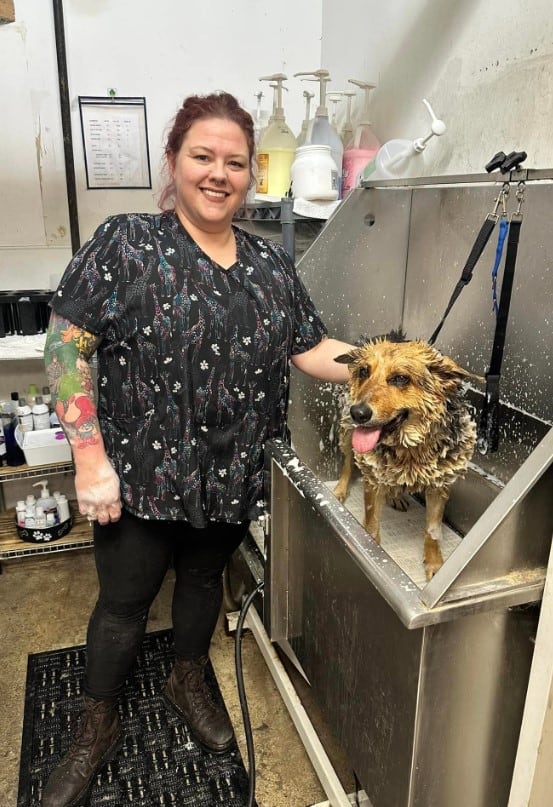 the woman is bathing the dog