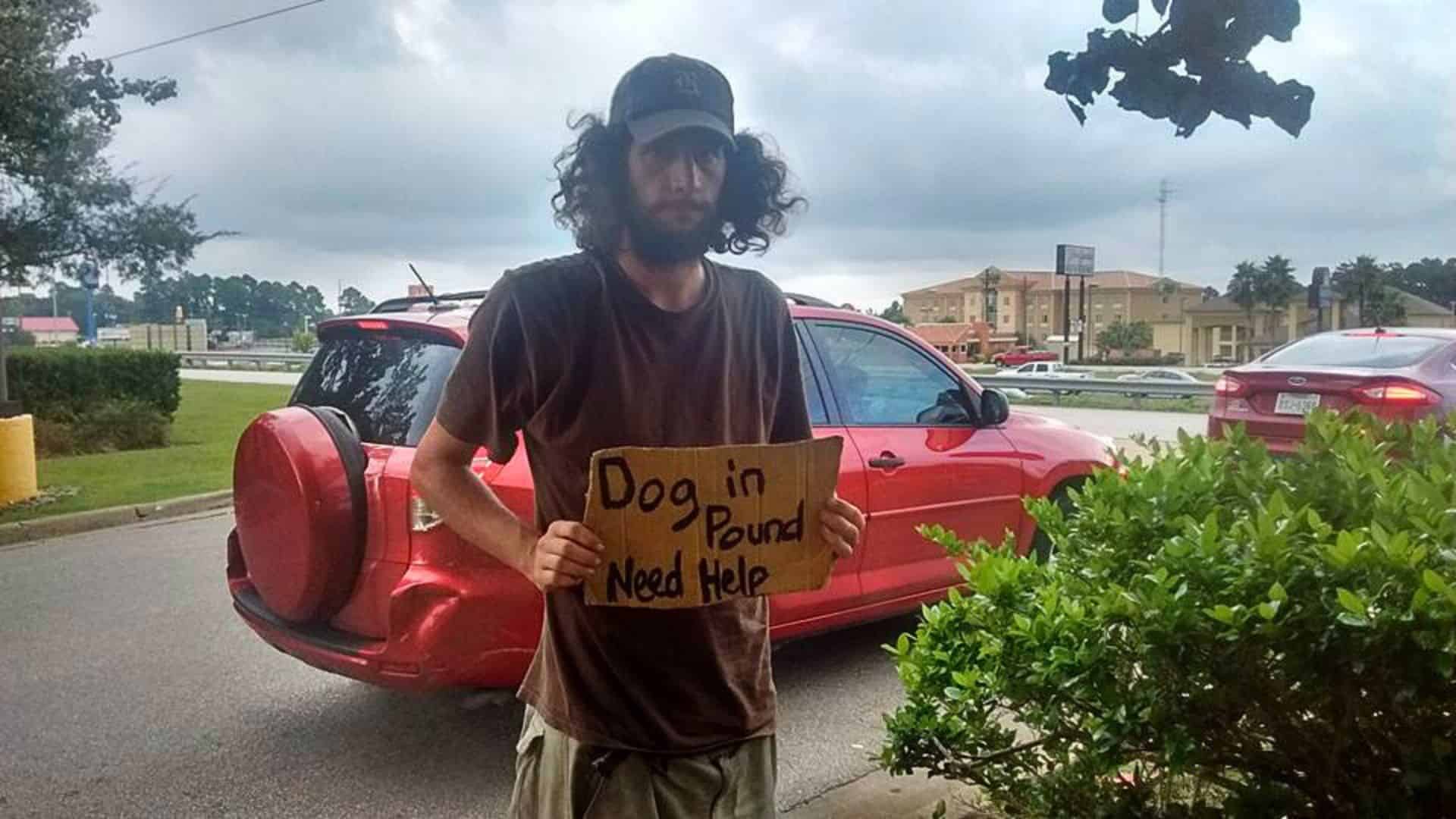 homeless man holding a sign