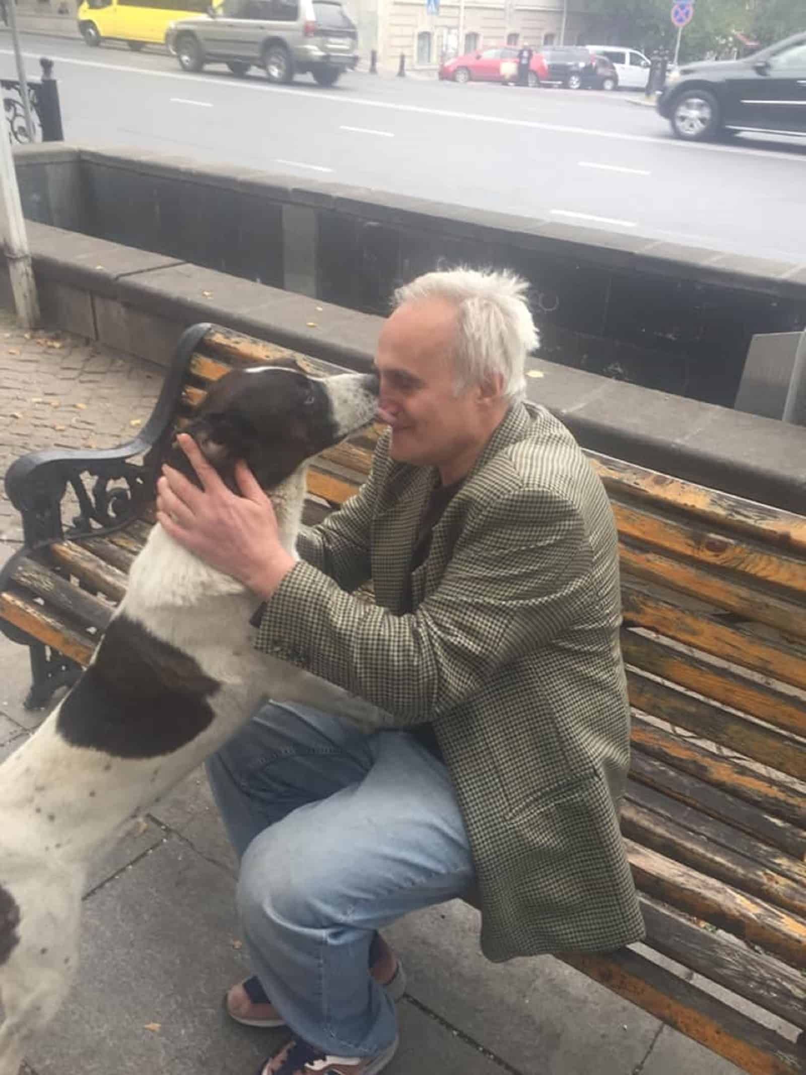 dog hugging his dog on the street