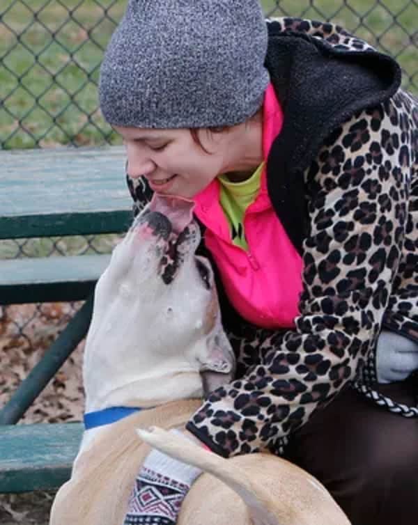 dog licking his owner in the park