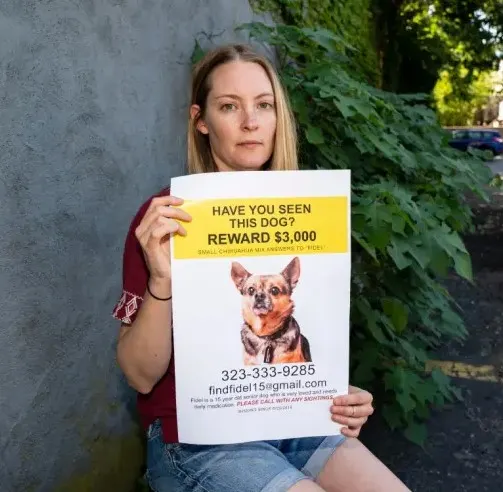 jessica sosteniendo un cartel para encontrar a su perro fidel