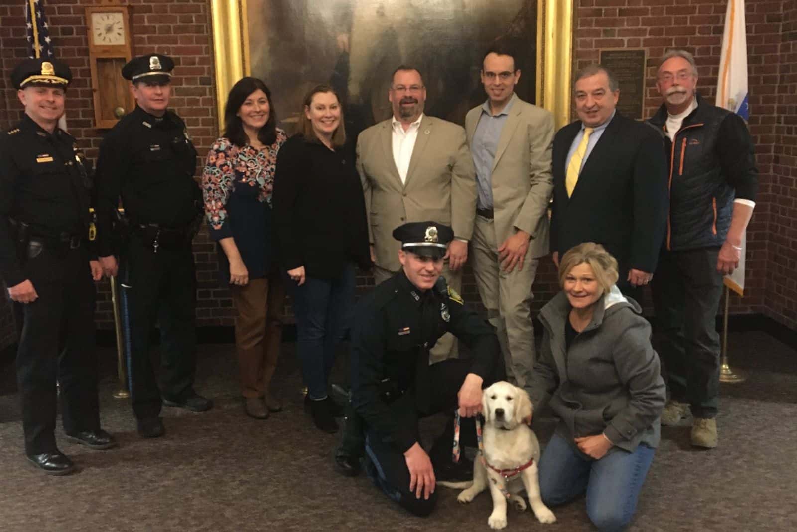 people from police department with cute puppy posing for photography