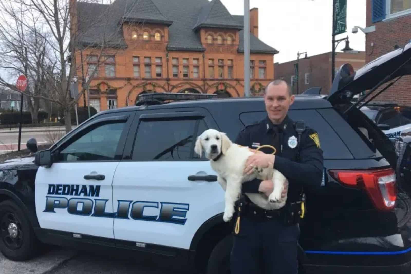 policeman holding cute puppy in his arms